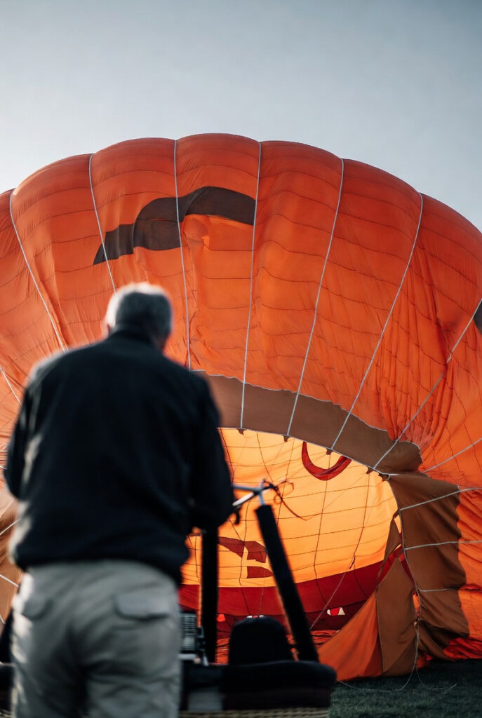 Man getting orange Hot Air Balloon Ready